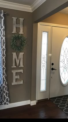 a door with the word home painted on it and a wreath hanging from the front door