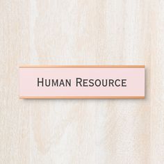 a pink sign that says human resources on the side of a wooden wall with black lettering