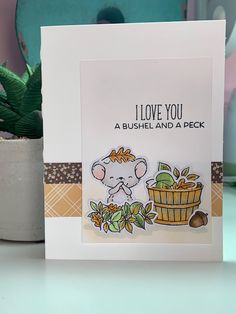 a card with an image of a mouse and a basket of fruit on the table