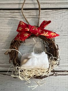 a wreath hanging on the side of a building with cotton in it and a red bow