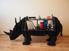 a rhino book shelf with books and other items on it's back legs, in the shape of a rhinoceros