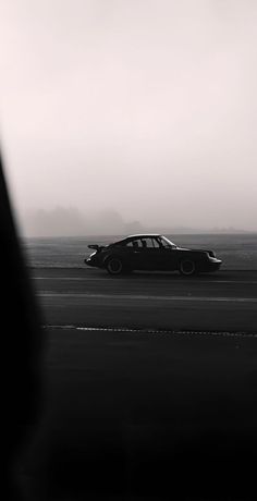 a car driving down the road on a foggy day