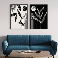 two black and white paintings on the wall above a blue couch in a living room