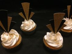 three cupcakes with white frosting and gold decorations