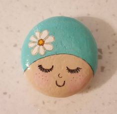 a close up of a rock with a face and a flower on it's head