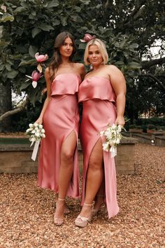 two women in pink dresses standing next to each other