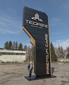 a man standing in front of a sign for a building that says tedrini