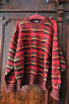 Beautiful True Vintage Carlo Colucci knit sweater from the 1990s. Made from a high quality wool blend fabric with multi color, structured wave knit in a warm color palette. Crew neck, relaxed cut, wide sleeves. Striped neck, cuffs and waistband. Carlo Colucci brand patch above the left cuff. Unisex. BRAND: Carlo Colucci ERA: 1990s COLOR: Red, sand, mustard, brown, khaki FABRIC: 70% new wool, 30% acrylic SIZE: Vintage men's size 52, fits best men's size L, but can also be worn by women - please c Striped Wool Sweater With Crew Neck, Striped Wool Crew Neck Sweater, Retro Striped Knitted Sweater, Striped Wool Sweater With Long Sleeves, Winter Jacquard Knit Striped Sweater, Winter Striped Jacquard Knit Sweater, Striped Jacquard Knit Sweater For Winter, 90s Brown Long Sleeve Sweater, Cheese Whiz