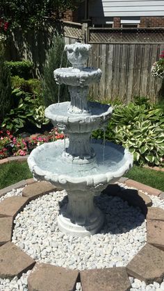 a water fountain in the middle of a garden