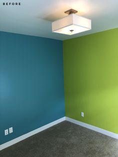 an empty room with blue and green walls, carpeted flooring and a square light fixture on the ceiling