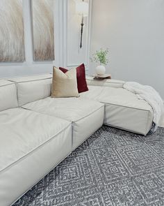 a large white couch sitting in a living room on top of a carpeted floor