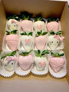 a box full of hello kitty chocolate covered strawberries with pink bows and green leaves