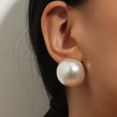 a close up of a person's ear with a pair of earrings on it