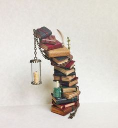 a stack of books with a candle hanging from it