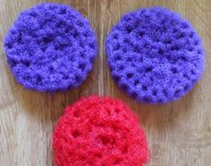 three crocheted round objects sitting on top of a wooden table