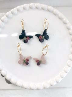 three pieces of jewelry sitting on top of a white plate