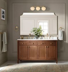 a bathroom with two sinks and a mirror on the wall next to a rug in front of it