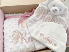 a baby gift set in a box with a teddy bear and blanket on the side