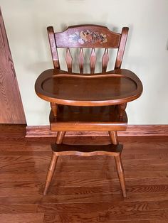 a wooden chair sitting on top of a hard wood floor next to a wall and door