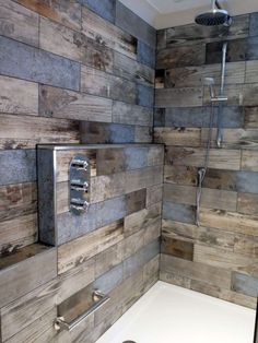 a bathroom with wood paneling on the walls and shower head in the corner, along with a white bathtub