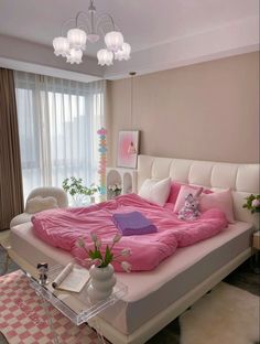 a bedroom with pink bedding and white furniture in the corner, along with a chandelier hanging from the ceiling