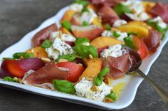 a white plate topped with fruit and feta cheese