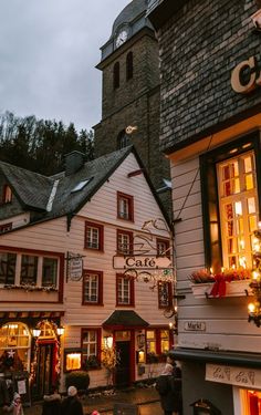 people are walking in front of a building with christmas decorations on the outside and inside