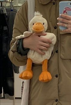 a person holding a stuffed duck in their arms