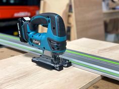 a cordless jig saw is on top of a piece of wood with green lines