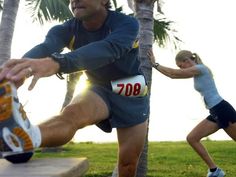 a man is running on the grass with other people behind him