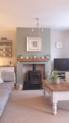 a living room filled with furniture and a fire place next to a wall mounted tv