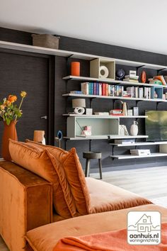 a living room filled with furniture and bookshelves next to a wall mounted tv