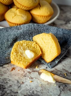 two muffins sitting on top of a table next to a pile of other muffins