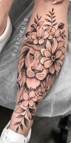 a woman's leg with flowers and a lion on it