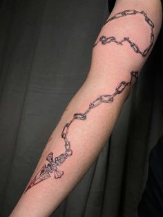 a man's arm with a chain tattoo on it