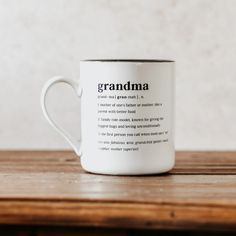 a white coffee mug with the words grandma printed on it sitting on a wooden table