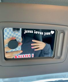 someone is holding their hand in the back seat of a car with jesus loves you sticker on it