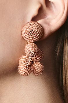 a close up of a person's ear wearing some kind of gold colored earrings