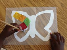 a child is making a paper butterfly craft