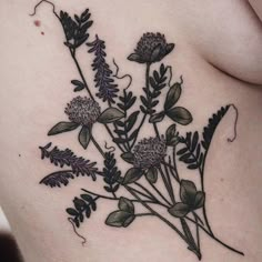 a woman's stomach with flowers and leaves on it