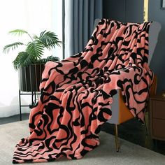 a pink and black blanket sitting on top of a chair