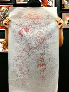 a person holding up a drawing in front of their face