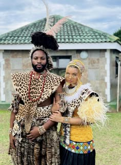 two people dressed in native clothing standing next to each other