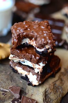 three pieces of chocolate and marshmallow ice cream sandwich on a wooden cutting board