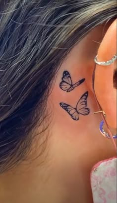 a woman's ear with two butterflies on it