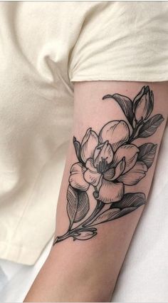 a black and white flower tattoo on the arm