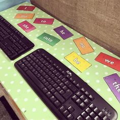 two keyboards sitting next to each other on top of a green table covered in sticky notes