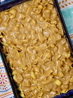 a pan filled with some kind of food on top of a colorful table cloth,