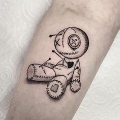 a small black and white tattoo of a teddy bear