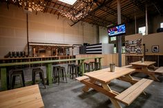 the inside of a restaurant with wooden tables and stools in front of a flat screen tv